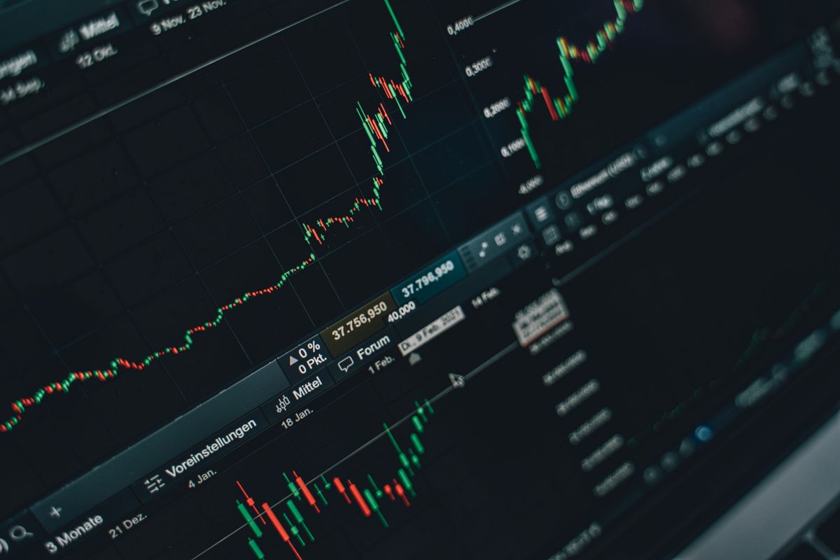Multiple market graphs on a laptop screen, quiet and steady